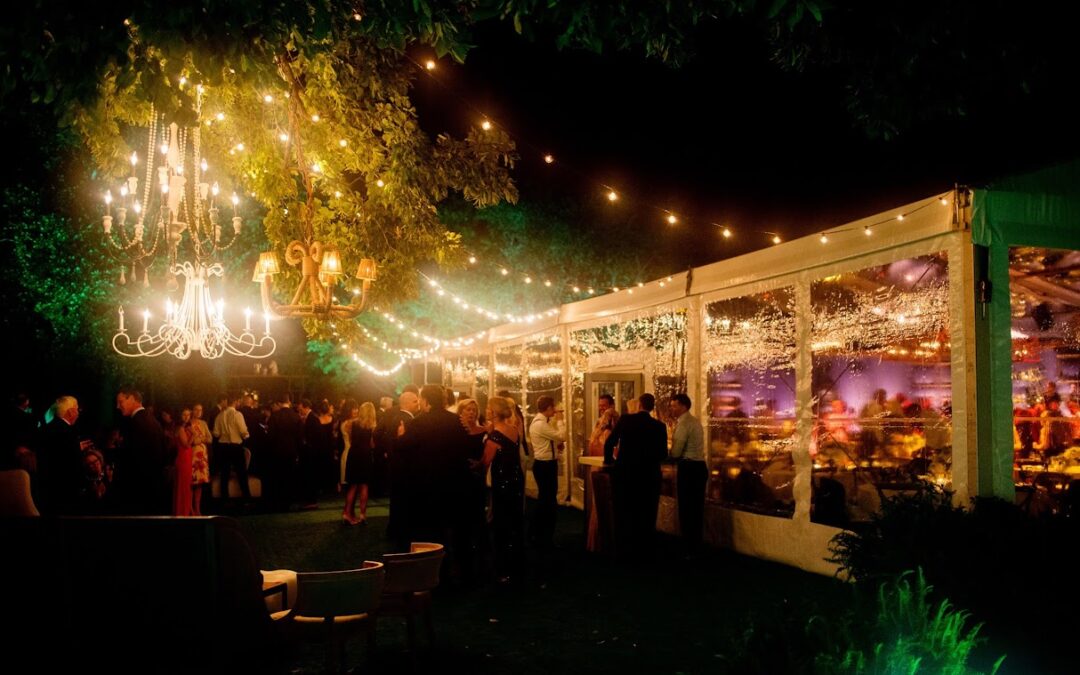 A beautiful cannabis-infused wedding reception held outdoors with a group of relaxed, happy guests enjoying curated cannabis selections.